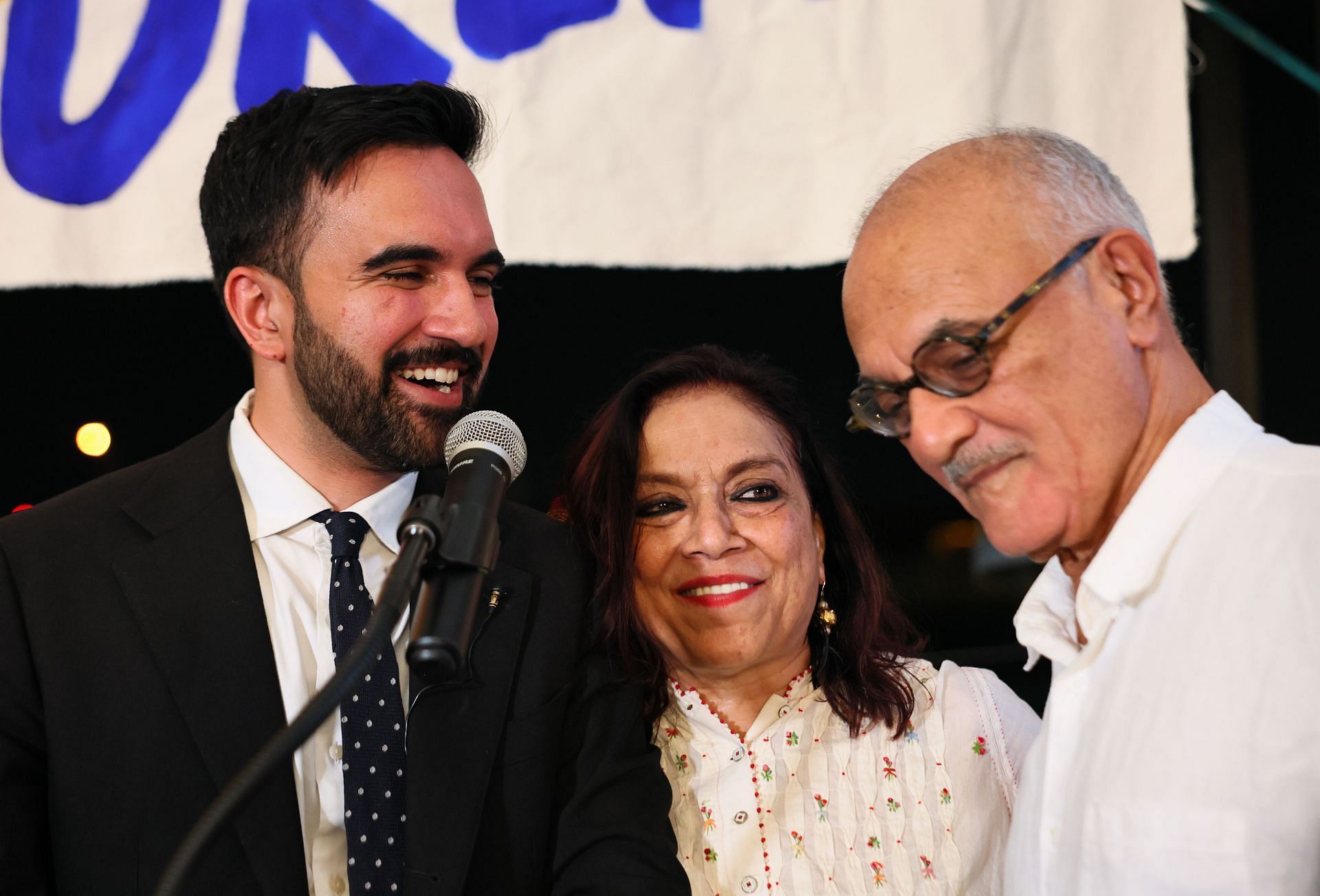 (L-R) Zohran Mamdani stands with his mother Mira Nair, and father Mahmood Mamdani as they celebrate at The Greats of Craft LIC on June 24, 2025. (Image via Getty)
